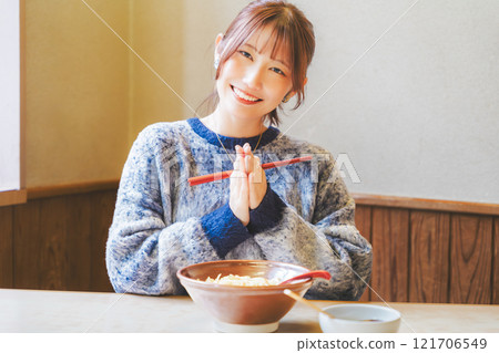 Young woman eating ramen after saying itadakimasu Young woman eating ramen after saying itadakimasu 121706549