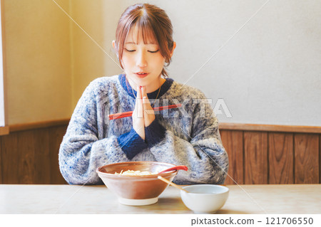 Young woman eating ramen after saying itadakimasu Young woman eating ramen after saying itadakimasu 121706550