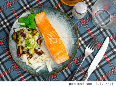 Fried salmon fillet and vegetable side dish, guacamole paste, slices of cheese and tomato slices 121706841