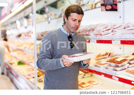Man looking for packaged mutton in grocery store Man looking for packaged mutton in grocery store 121706851