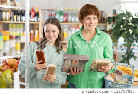 Woman with a child chooses sweets 121707033