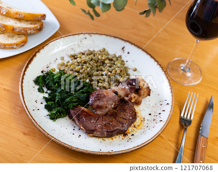 Beef with lentils and spinach served on platter Beef with lentils and spinach served on platter 121707068