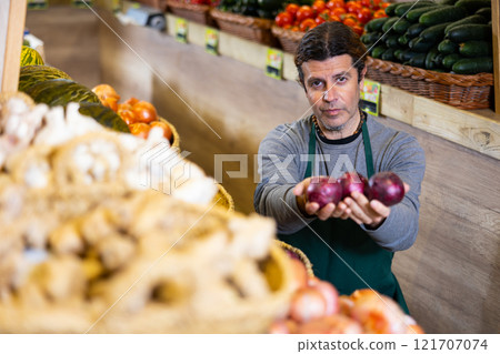 Adult man selling onions in shop 121707074