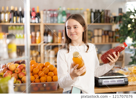 Teenage girl chooses peach and tomato juices 121707076