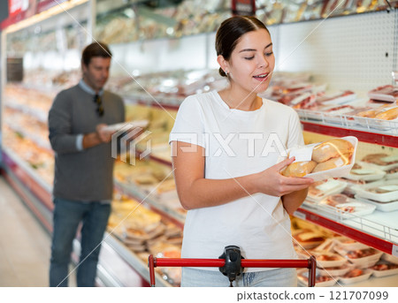 Woman choosing packaged chicken in supermarket Woman choosing packaged chicken in supermarket 121707099