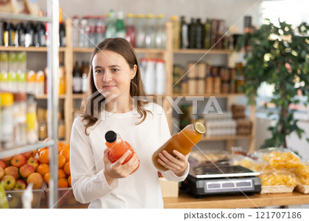 Teenage girl chooses grapefruit and peach juices Teenage girl chooses grapefruit and peach juices 121707186