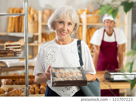 Elderly woman with box of cookies 121707223
