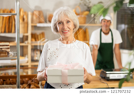Elderly woman with box of pastries 121707232