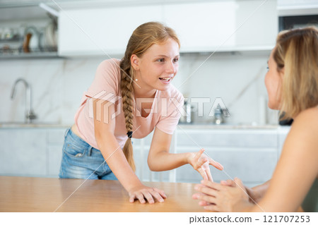 Teenage daughter enthusiastically tells unrecognizable mother about planned vacation with friends 121707253