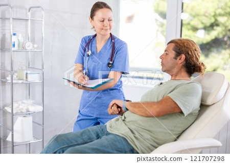 Adult female doctor signing contract with male patient 121707298