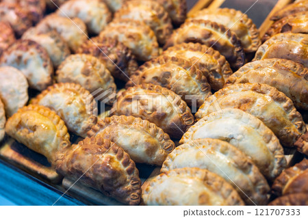 Delicious empanadas lined up in rows in store window 121707333