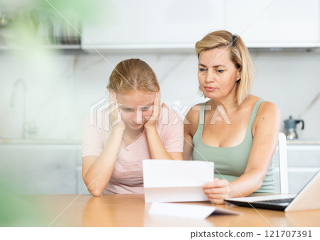 Upset and distressed mother and teenager daughter reads letter and learns unpleasant news Upset and distressed mother and teenager daughter reads letter and learns unpleasant news 121707391