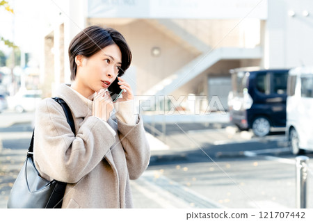 A woman talking on a smartphone 121707442