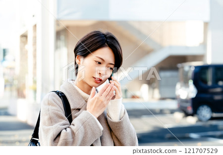 A woman talking on a smartphone A woman talking on a smartphone 121707529