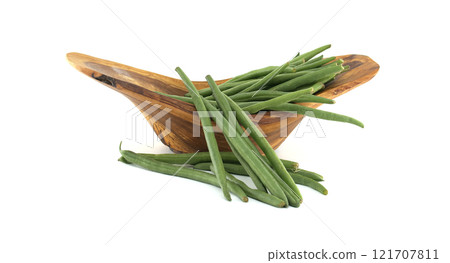 Fresh green beans overflowing a wooden bowl on white background 121707811