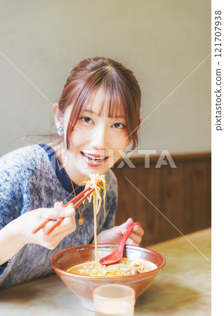 快樂的年輕女人吃美味的拉麵 快樂的年輕女人吃美味的拉麵 121707938