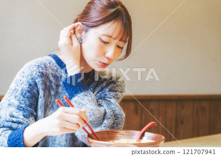 Happy young woman eating delicious ramen Happy young woman eating delicious ramen 121707941