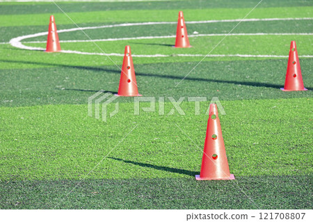 artificial green grass soccer field with orange training cones 121708807