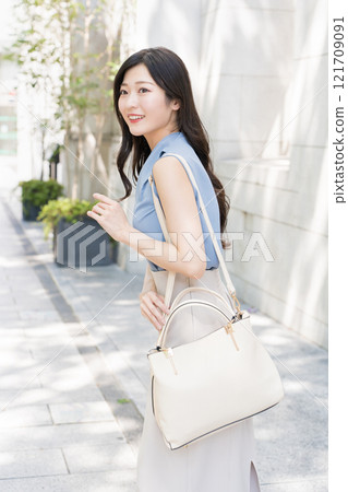 Business woman walking with a shoulder bag 121709091