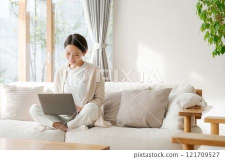 一位女士在客廳使用電腦 121709527