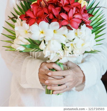 Woman hand wearing a diamond ring and holding flower bouquet. Idea for marriage proposal, romantic surprise, wedding, engagement and valentines day concept Woman hand wearing a diamond ring and holding flower bouquet. Idea for marriage proposal, romantic surprise, wedding, engagement and valentines day concept 121710503