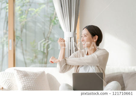 A woman working on a computer and stretching A woman working on a computer and stretching 121710661