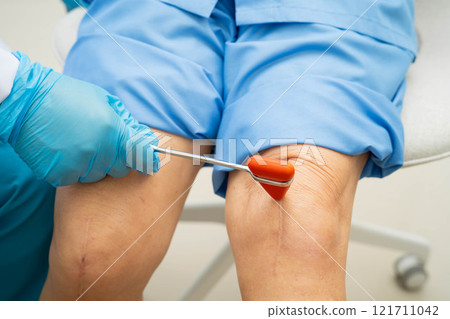 Asian doctor knock on knee reflex nerve for check and treatment senior patient in hospital. 121711042