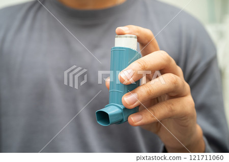 Asthma and chronic obstructive pulmonary disease COPD, Asian young man using metered dose inhaler MDI. 121711060