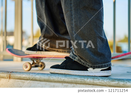 Skateboarder riding on pink skateboard at skatepark 121711254