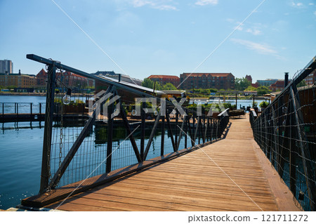 Wooden walkway leading to stylish restaurant on city embankment 121711272