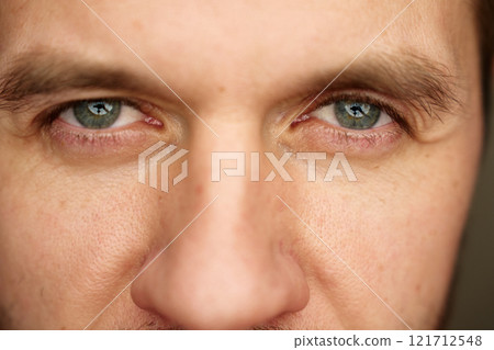 Intense gaze with gray eyes. Male face with focused expression. Intense gaze with gray eyes. Male face with focused expression. 121712548