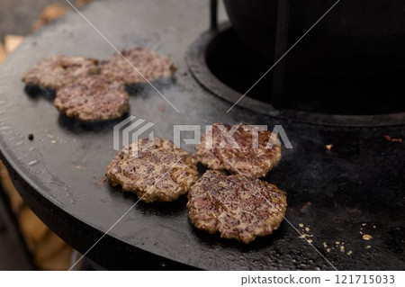 Sizzling, Mouthwatering Burgers Cooking Perfectly on a Griddle at a Summer BBQ Event 121715033