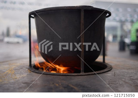 The Glow of Embers and Flames in a Steel Cooking Pot Outdoors Under the Starry Sky 121715050