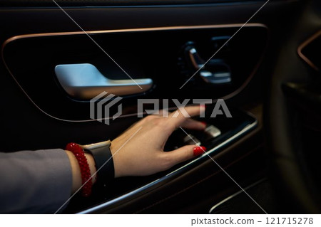 An Elegant Automobile Interior Featuring a Hand Gracefully Positioned on Door Controls An Elegant Automobile Interior Featuring a Hand Gracefully Positioned on Door Controls 121715278