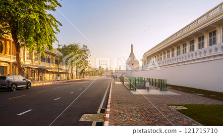 Na Phra Lan Road in front of The Bangkok Grand Palace featuring white walls and traditional architecture under a sunrise sky. Na Phra Lan Road in front of The Bangkok Grand Palace featuring white walls and traditional architecture under a sunrise sky. 121715710