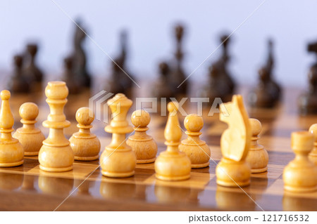 Wooden white chess pieces on the chessboard Wooden white chess pieces on the chessboard 121716532