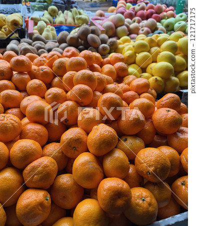 A vibrant market stall featuring a variety of fresh fruits, including tangerines, lemons, apples, oranges, and kiwis in Serbia A vibrant market stall featuring a variety of fresh fruits, including tangerines, lemons, apples, oranges, and kiwis in Serbia 121717175