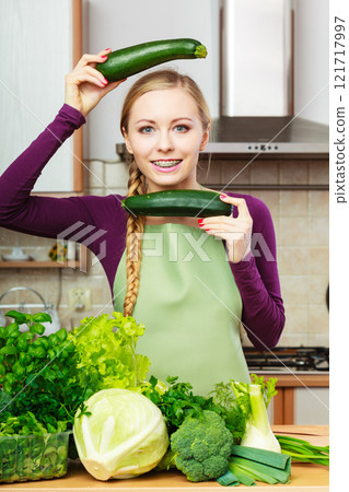 Woman housewife in kitchen with green vegetables 121717997