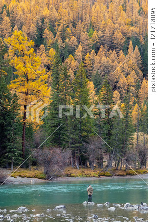 fisherman catches grayling in a mountain river 121718095