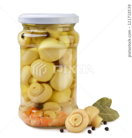 Marinated mushrooms in a glass jar close-up on a white background. Isolated Marinated mushrooms in a glass jar close-up on a white background. Isolated 121718539