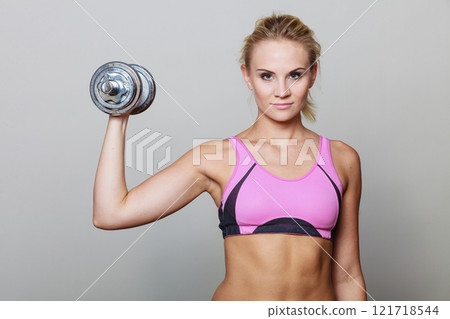 Fit woman lifting dumbbells weights 121718544
