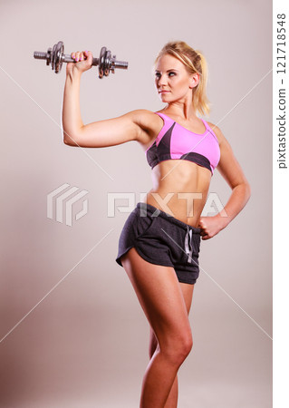 Fit woman lifting dumbbells weights 121718548
