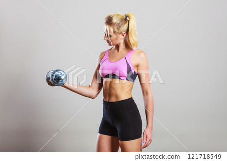 Fit woman lifting dumbbells weights 121718549