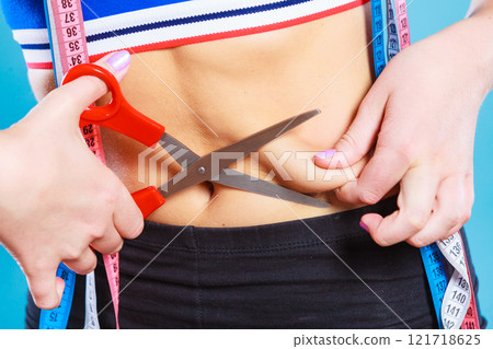 Woman pinching waist for skin fold test Woman pinching waist for skin fold test 121718625