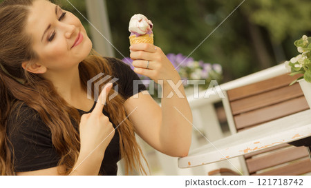 Young woman eating ice cream Young woman eating ice cream 121718742