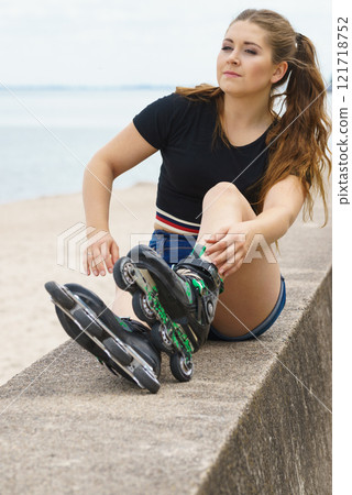 Girl wearing roller skates on seaside Girl wearing roller skates on seaside 121718752