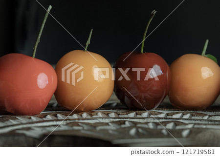 Detail of Deletable imitation fruits (Kanom look choup)  in the shape of oranges, rose apple and strawberries has a sweet taste. 121719581