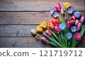 A rustic arrangement of colorful spring flowers on a wooden backdrop, emphasizing their natural charm. 121719712