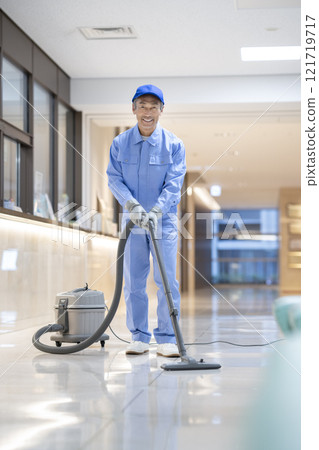 Senior cleaning staff cleaning a building, smiling portrait looking at the camera Senior cleaning staff cleaning a building, smiling portrait looking at the camera 121719717