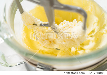 Close-up of a stand mixer creaming together butter and sugar for the Chocolate Ginger Sugar Cookie Dough, creating a light, fluffy base. 121720888